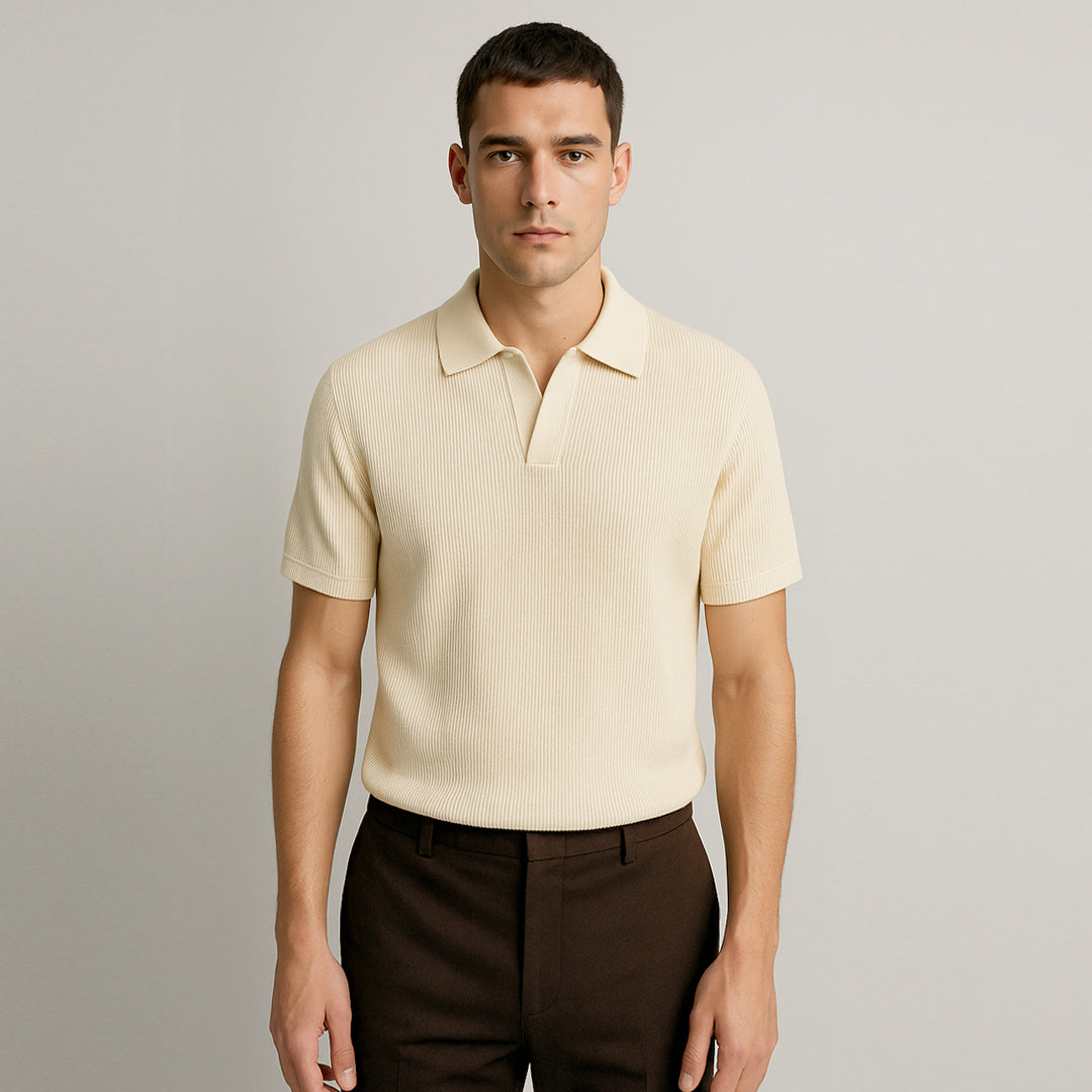 Man wearing a cream ribbed short sleeve polo shirt and dark brown trousers