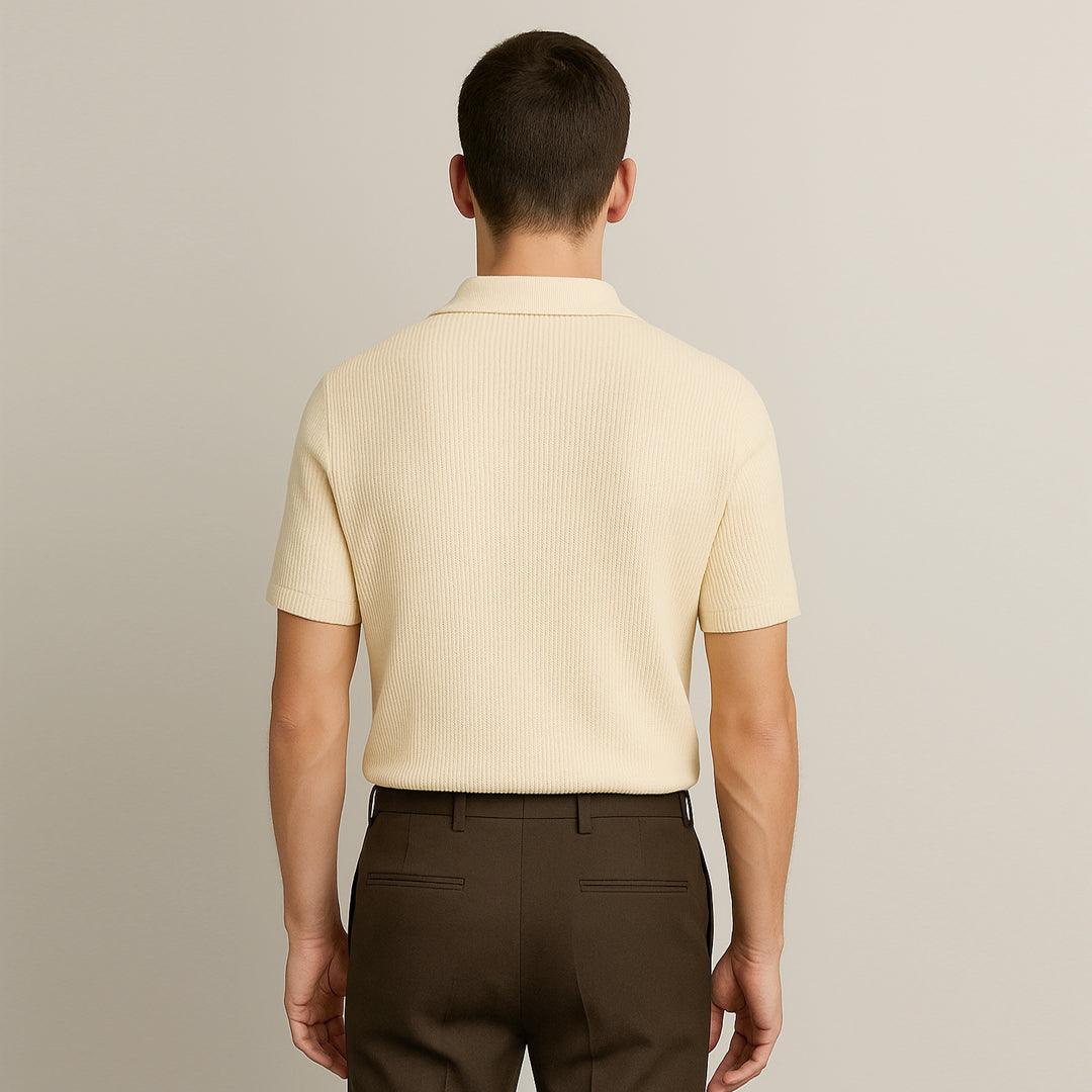 Back view of man wearing cream ribbed polo shirt and brown trousers, neutral background