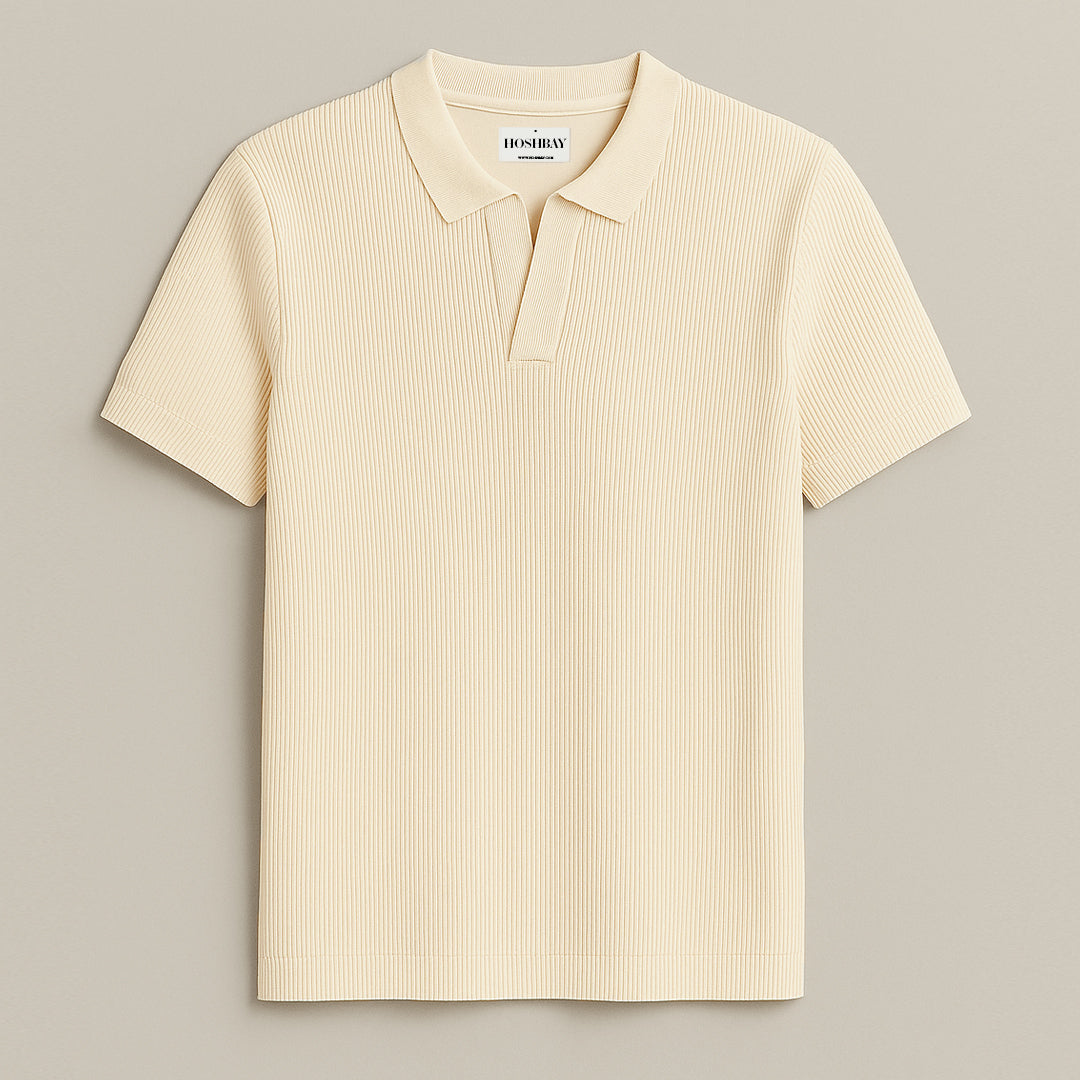 Man wearing a cream ribbed short sleeve polo shirt and dark brown trousers
