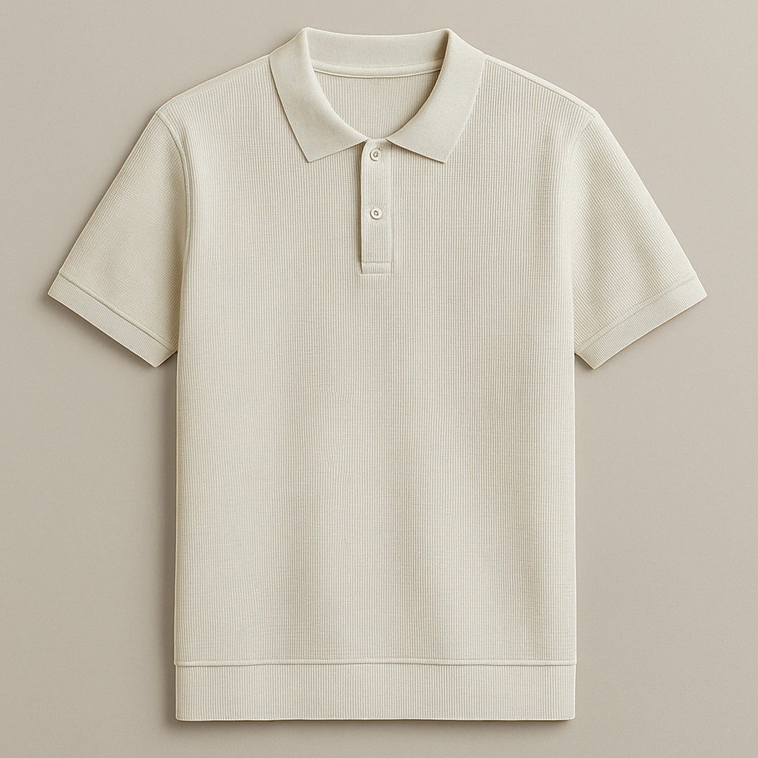 Man wearing a beige textured short sleeve polo shirt with black pants, neutral background