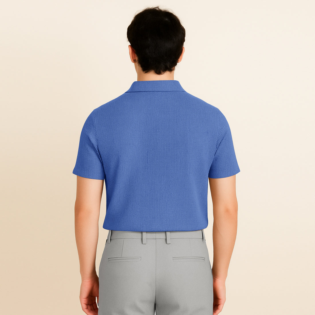 Man wearing a textured azure blue short sleeve polo shirt and light grey pants