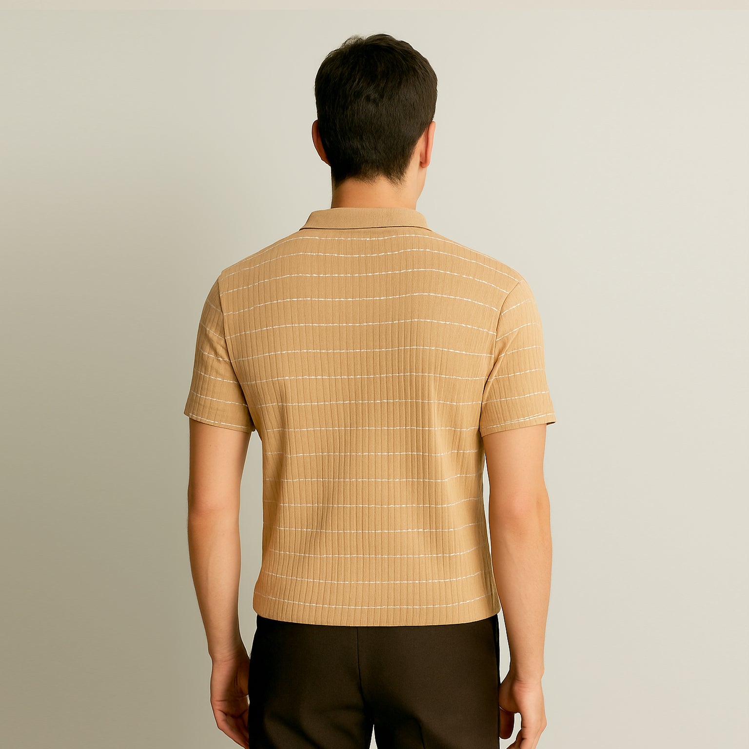 Back view of man wearing short sleeve beige striped polo shirt and dark pants