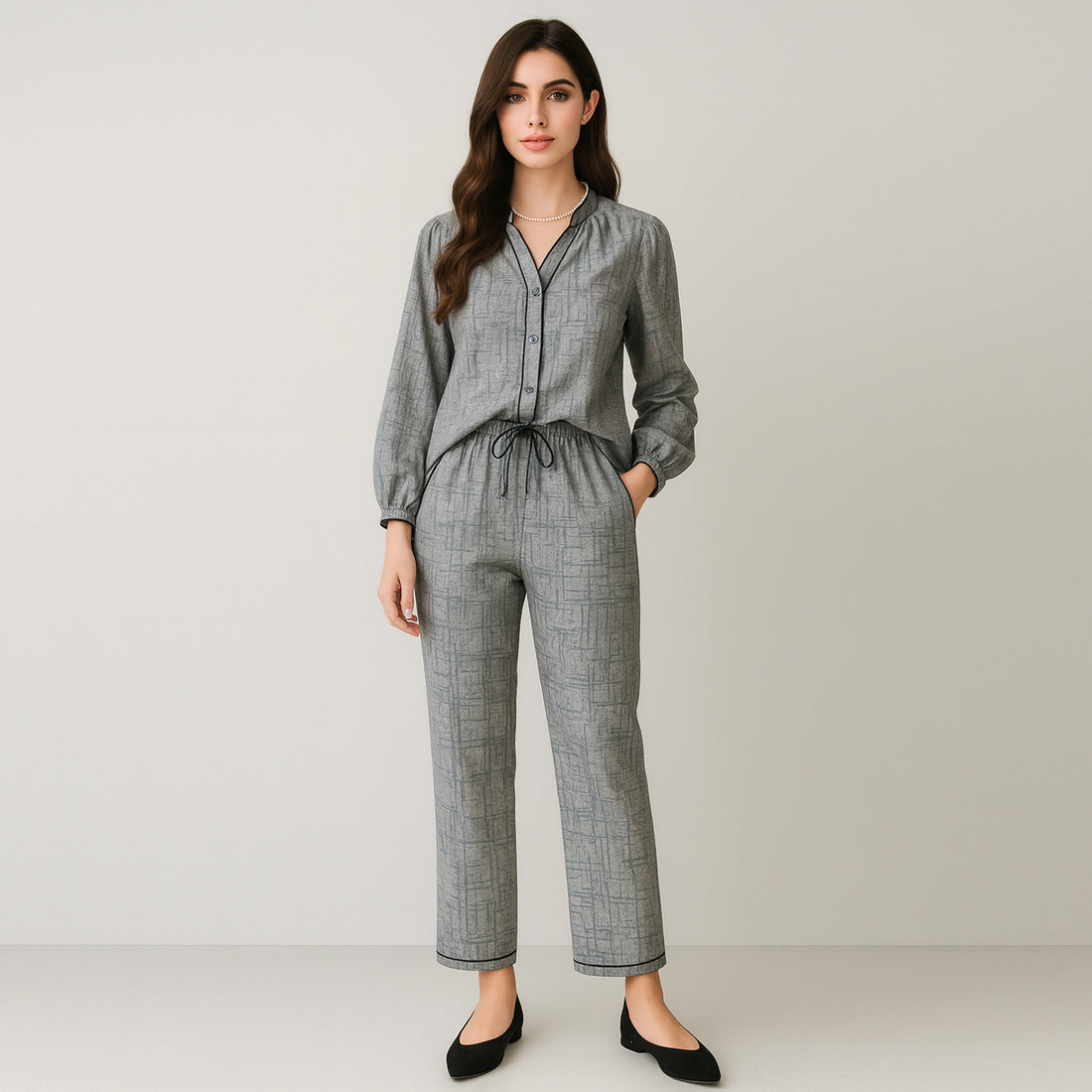 Woman wearing grey matching shirt and trousers set with geometric pattern, stylish casual wear.