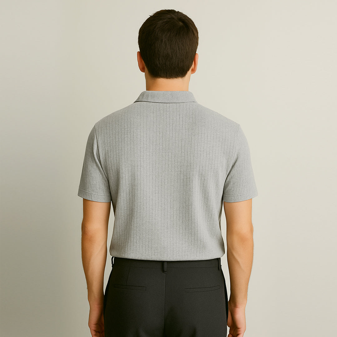 Back view of a man wearing a light grey short-sleeve polo shirt and black trousers