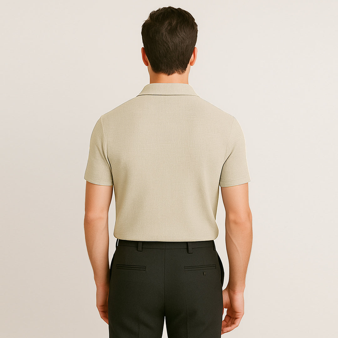Man wearing short sleeve ivory polo shirt and black pants, back view, neutral background