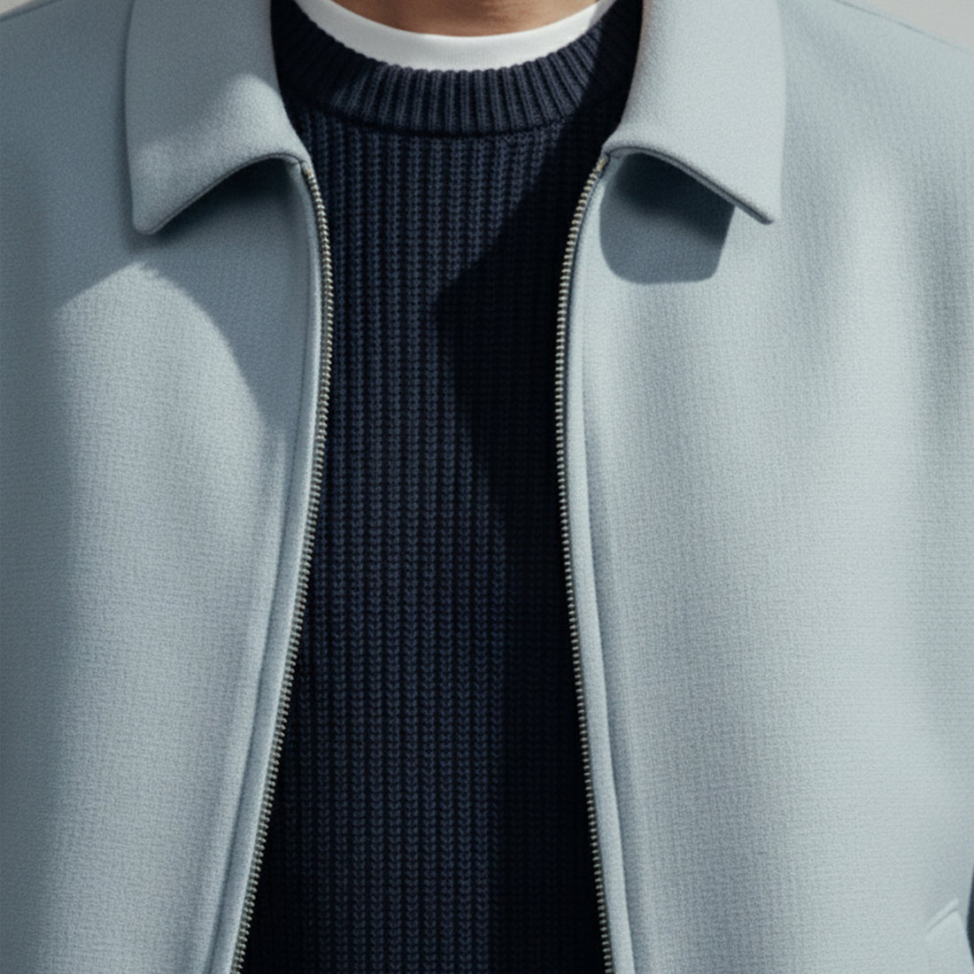 Men's grey zip-up coat with collar, front pockets, and minimalist design on white background