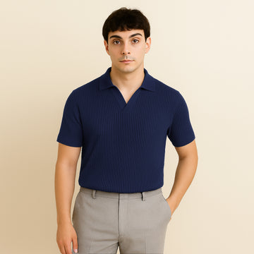 Man wearing a navy blue ribbed short sleeve polo shirt and beige trousers