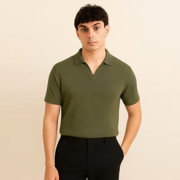 Man wearing olive green short sleeve polo shirt and black pants, neutral background