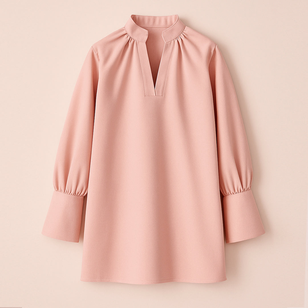 Pink women's tunic with long puff sleeves and mandarin collar on plain background