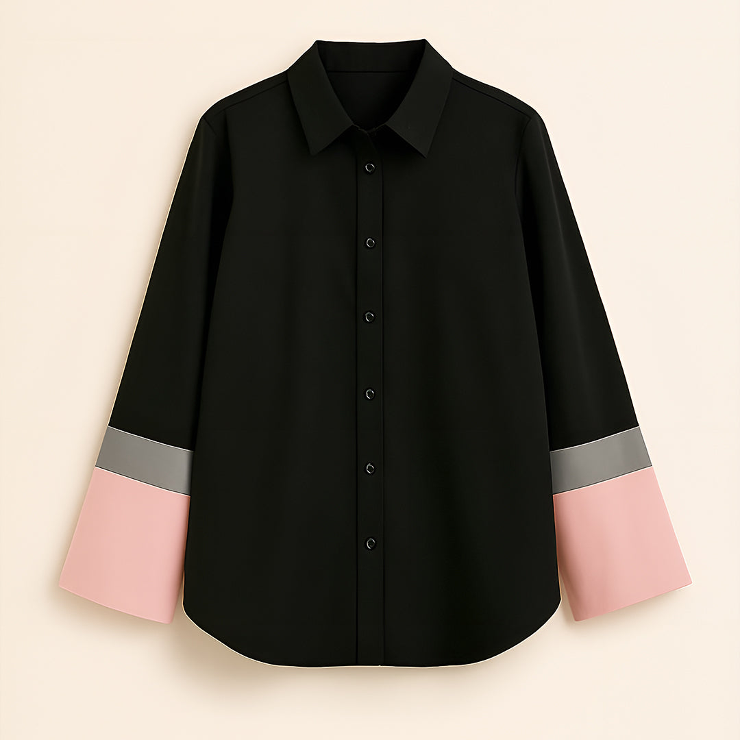 Black button-up shirt with pink and gray color block sleeves, laid flat on beige background