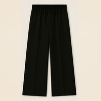 Black wide-leg trousers with elastic waistband, flat front, and straight hem on beige background.