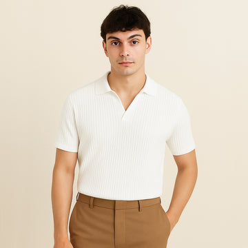 Man wearing a white ribbed short sleeve polo shirt with brown trousers, neutral background