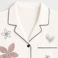 White shirt with black piping, botanical embroidery, notched collar, single chest pocket